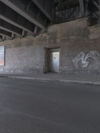 a view inside of a building with graffiti on the walls and sidewalk area below it