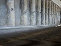 the parking garage of an old concrete building has a bunch of large pillars sticking out