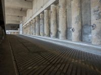 the parking garage of an old concrete building has a bunch of large pillars sticking out