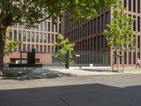 a woman walking across the street on her skateboard at an intersection with a building in the background