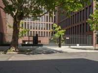 a woman walking across the street on her skateboard at an intersection with a building in the background