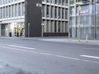 a large building is reflected in the side of the street that goes along this narrow road