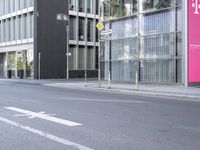 a large building is reflected in the side of the street that goes along this narrow road