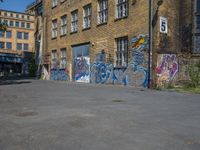 a parking lot in an abandoned city with graffiti on it, including windows, and a door