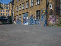 a parking lot in an abandoned city with graffiti on it, including windows, and a door