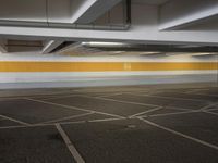an empty parking lot with a yellow stripe on it's wall and two white lights