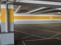 an empty parking lot with a yellow stripe on it's wall and two white lights