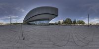 a panoramic view of a large building and its circular exterior space has a lot of glass windows