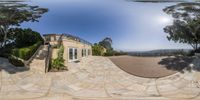 this 360 - view shows the driveway and house at one end of the driveway with trees and plants and shrubs on the far side