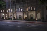 the night lights shine on the exterior of the building that houses a hotel and bar