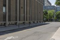 a brick building with bicycle lanes on the sidewalk in front of it and buildings in the back