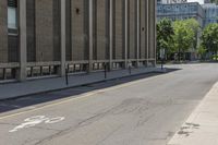 a brick building with bicycle lanes on the sidewalk in front of it and buildings in the back