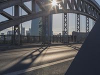 a bicycle path on a bridge over the street in the city sunbeams on the railing