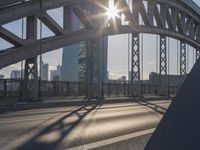 a bicycle path on a bridge over the street in the city sunbeams on the railing