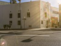 a man riding his bicycle on the sidewalk in front of a building with palm trees and a large sign