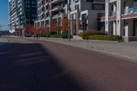 a bicycle sitting on the side of the road next to two tall buildings in the city