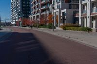 a bicycle sitting on the side of the road next to two tall buildings in the city