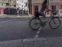 a blurry photo of a bicycle riding on the street in front of people on bikes