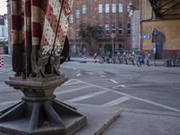 two rows of bicycles in front of an area covered by brick buildings and other buildings