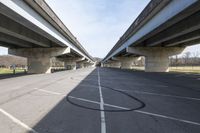 a view of a very big bridge from the side of the street in front of an empty parking lot