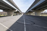 a view of a very big bridge from the side of the street in front of an empty parking lot