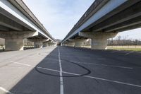 a view of a very big bridge from the side of the street in front of an empty parking lot