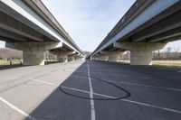 a view of a very big bridge from the side of the street in front of an empty parking lot