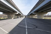 a view of a very big bridge from the side of the street in front of an empty parking lot