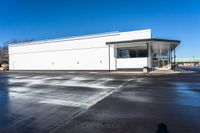 a big empty commercial building sits on the corner of a street side lot with its parking lot