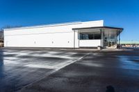 a big empty commercial building sits on the corner of a street side lot with its parking lot