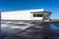 a big empty commercial building sits on the corner of a street side lot with its parking lot