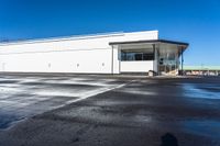 a big empty commercial building sits on the corner of a street side lot with its parking lot