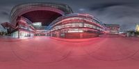 a red and white building that is very big in size and color outside, with a circular design, at night