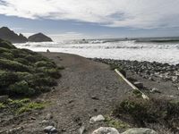 a man is riding his surfboard in the water at beach, waves, rocks, and large rock shoreline