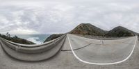 two images of a road and a view of the ocean below, and on one side of each image are mountains