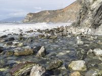 the water is clean and running near the rocks in the shallow water area of the beach