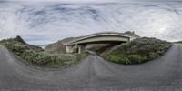 a road with a curved, overhang and overhang on one side under a cloudy sky