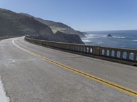 a motorcycle is parked on the side of the road near a ocean shore covered with cliffs