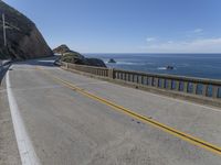 a motorcycle is parked on the side of the road near a ocean shore covered with cliffs