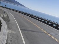 the winding highway runs along the coast with cliffs in the distance next to the ocean