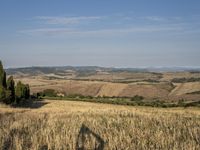 a bike is parked in the middle of a field near the hillside of a hilly country side