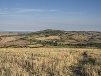 a bike is parked in the middle of a field near the hillside of a hilly country side