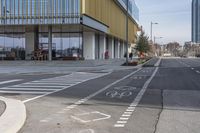 a bike path that looks like a crosswalk for pedestrians on a street by a building