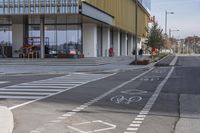 a bike path that looks like a crosswalk for pedestrians on a street by a building