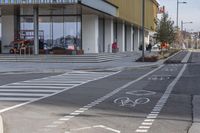 a bike path that looks like a crosswalk for pedestrians on a street by a building