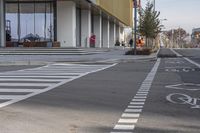 a bike path that looks like a crosswalk for pedestrians on a street by a building