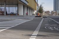 a bike path that looks like a crosswalk for pedestrians on a street by a building