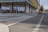 a bike path that looks like a crosswalk for pedestrians on a street by a building