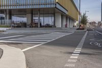 a bike path that looks like a crosswalk for pedestrians on a street by a building