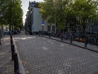 bike racks line a road with parked bicycles in the distance on an old brick road